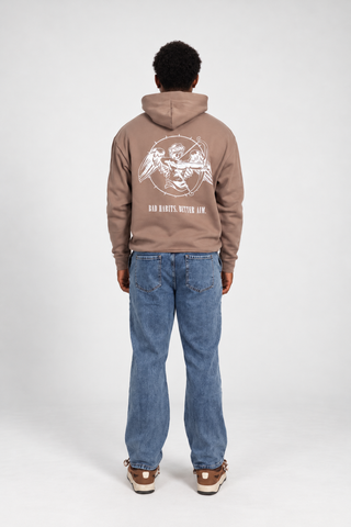 Back full-body studio view of a model wearing the Clay Bad Habits Hoodie, showing the cupid archer graphic and BAD HABITS. BETTER AIM. text.