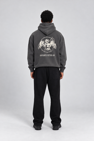 Back full-body studio view of a model wearing the Grey Bad Habits Hoodie, showing the cupid archer graphic and BAD HABITS. BETTER AIM. text.