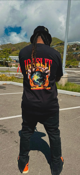 Person wearing a black t-shirt with colorful graphics and text, standing outdoors.