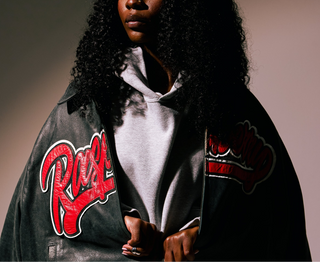 Person wearing a RASBERRY branded jacket over an A Strangers Love grey logo hoodie over a plain background