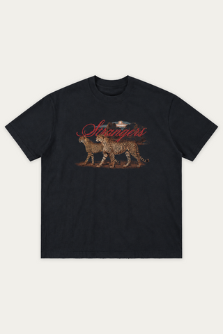 Black washed t-shirt with a vintage-style graphic of two cheetahs walking side by side across red dirt in front of a rocky sunset, with Strangers in red script above.