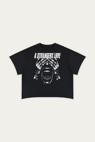 A black short-sleeve crop top t-shirt featuring a white graphic print of a screaming face with hands over its eyes and the text 'A STRANGERS LOVE' above it, displayed flat against a light off-white background.