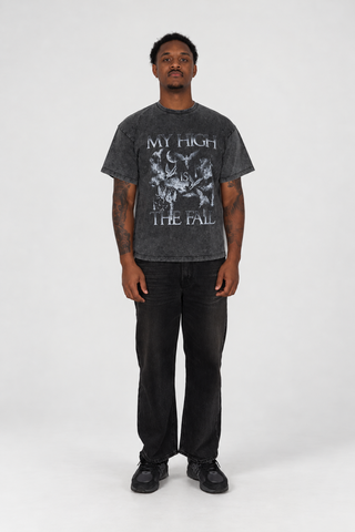 Front view of a model wearing The Fall T-Shirt in Grey Washed with black jeans and dark sneakers in a light studio.